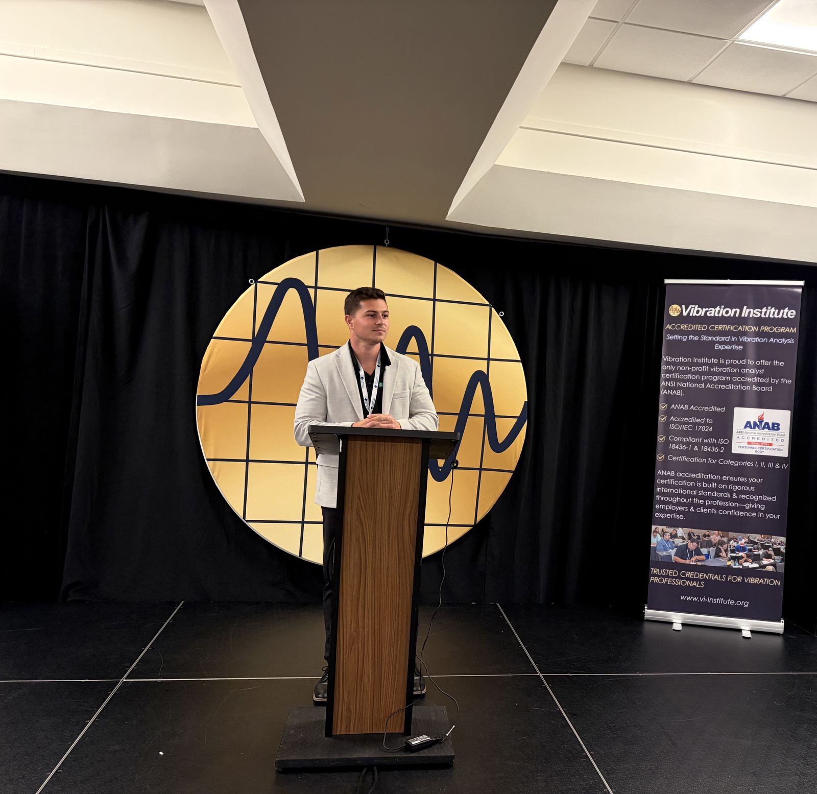 Pete speaking at a podium at a Vibration Institute event