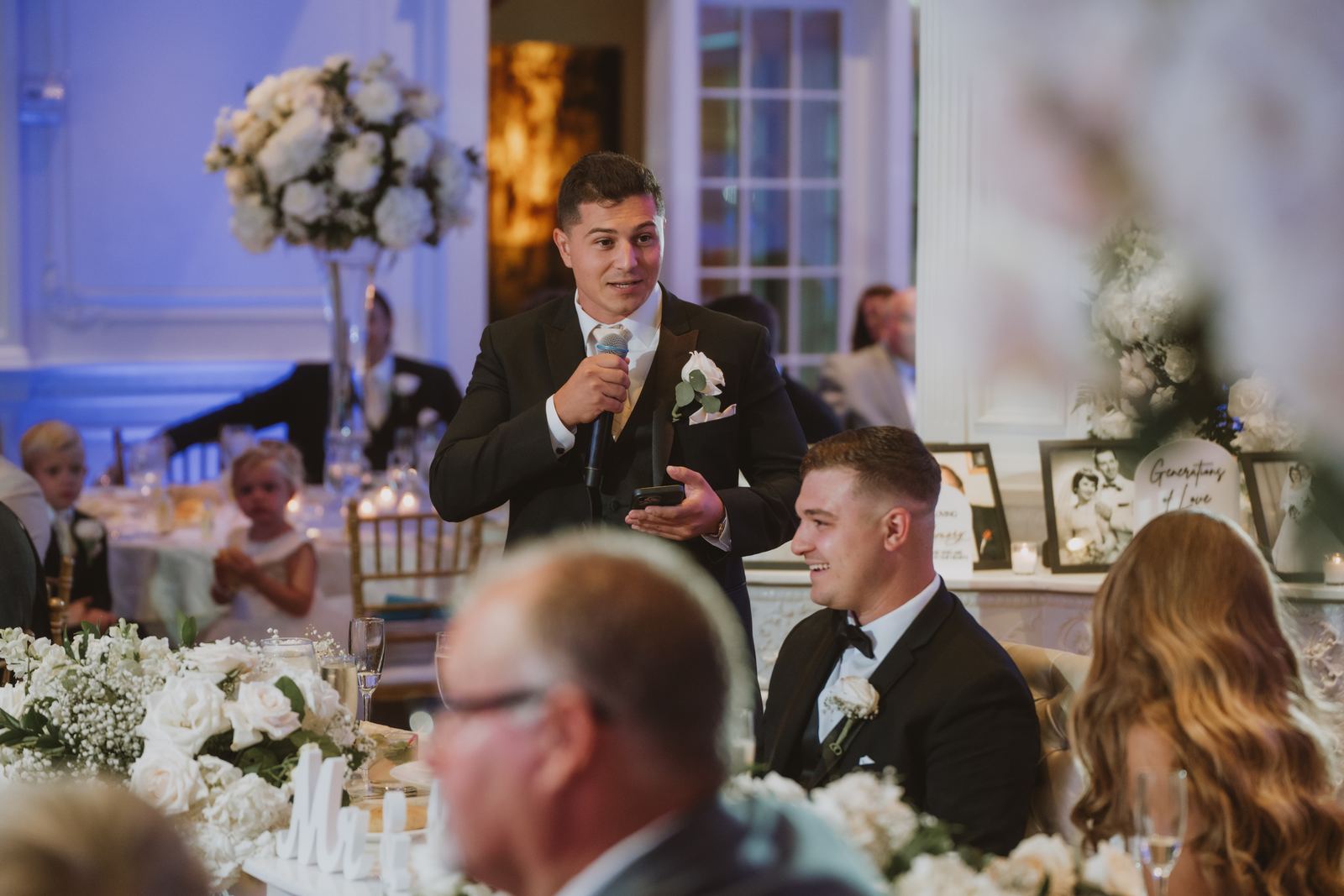 Pete giving a toast with a microphone at a wedding reception