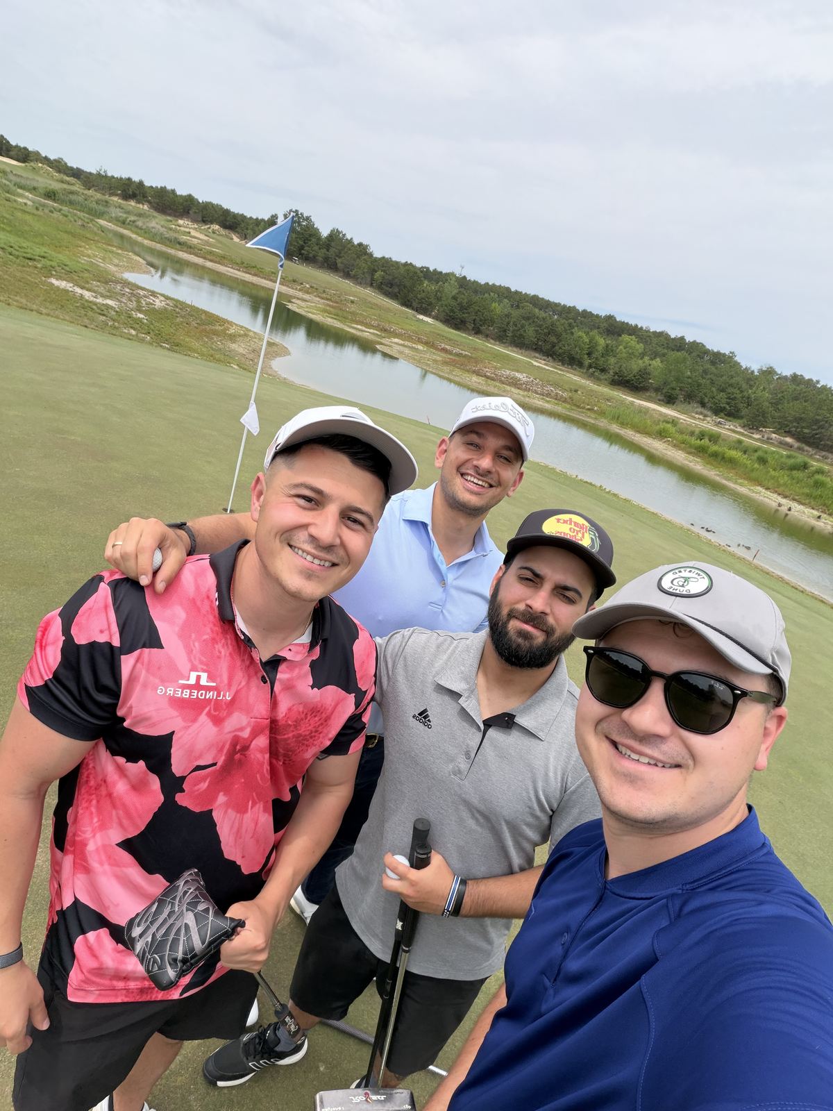 Pete and three friends taking a selfie on a golf course