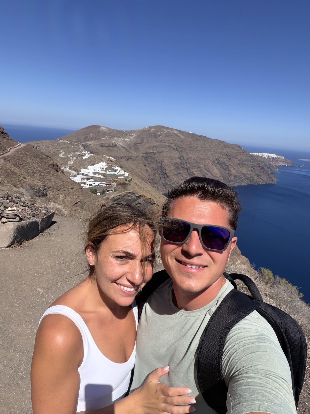 Pete and Cassie taking a selfie on a hiking trail above the Santorini caldera