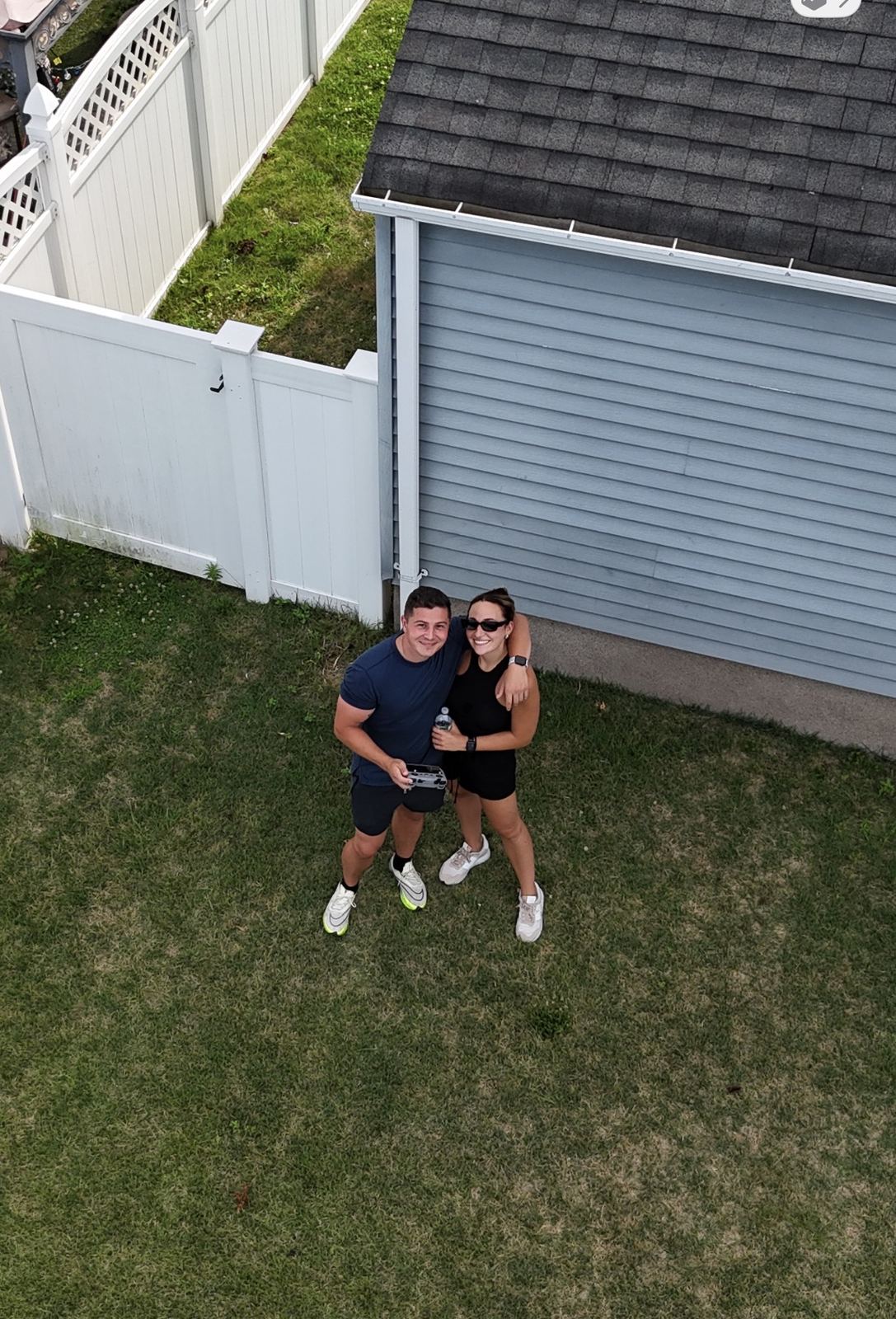 Overhead drone shot of Pete and Cassie standing in a backyard